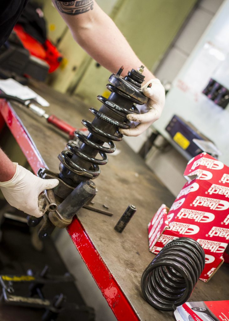 A mechanic with a coilover