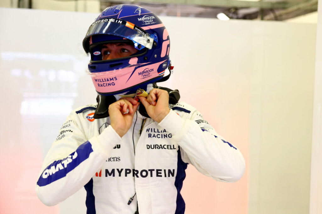 Williams F1 driver putting helmet on