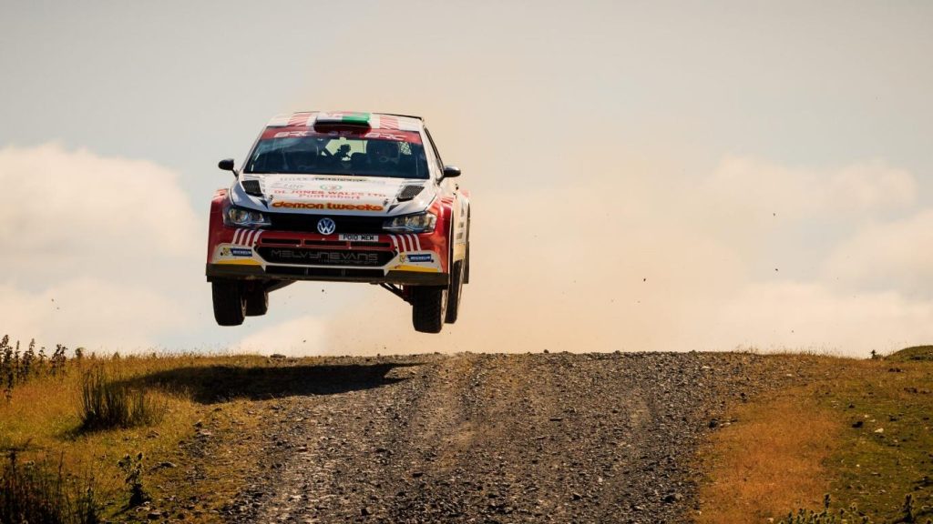 A red car driving on a dirt road
